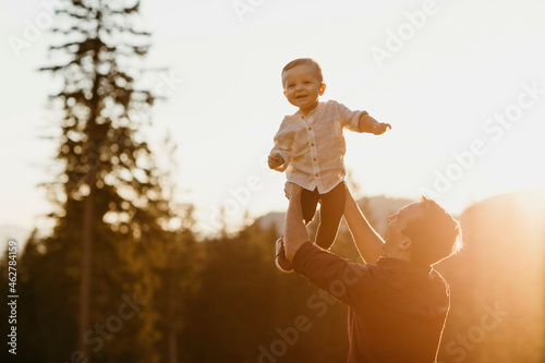 Happy father lifting up little son outdoors at sunset, Schwaegalp, Nesslau, Switzerland photo
