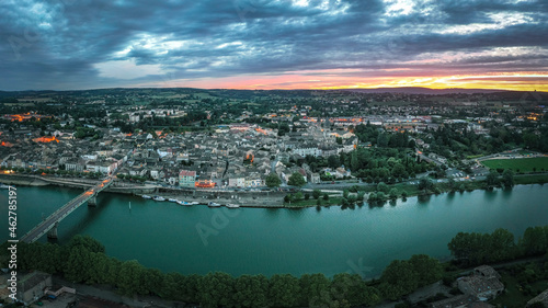 France, Saone-et-Loire, Tournus, Clouds over riverside city at sunset photo