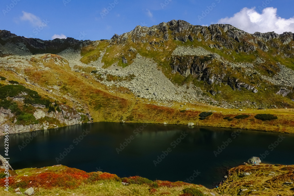 dark green mountain lake with many different colors in the mountains dark green mountain lake with many different colors in the mountains