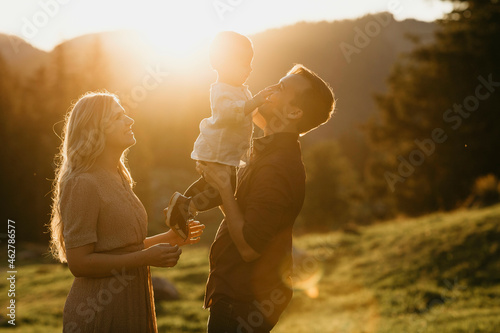 Happy family with little son on a hiking trip at sunset, Schwaegalp, Nesslau, Switzerland photo