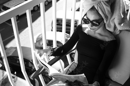 Glamour lady reading a magazine on balcony photo