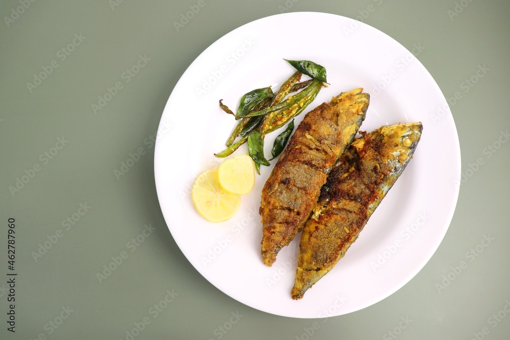 Indian Mackerel fish fry. Bangda Rava fry. whole Fried fish served on a banana leaf with fried chilies, lemon slices, and Indian spices. also known as talalele bangde in Marathi. Copy space. Indian Mackerel fish fry. Bangda Rava fry. whole Fried fish served on a banana leaf with fried chilies, lemon slices, and Indian spices. also known as talalele bangde in Marathi. Copy space.