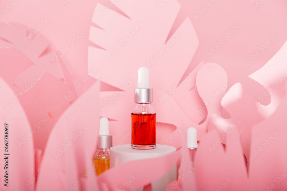 Dropper glass bottles with pipette standing on a white podium. Transparent hyaluronic natural beauty mineral product and eco serum skin care concept Dropper glass bottles with pipette standing on a white podium. Transparent hyaluronic natural beauty mineral product and eco serum skin care concept