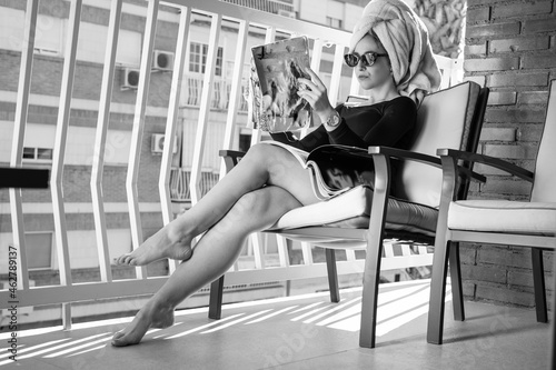 Glamour lady reading a magazine on balcony