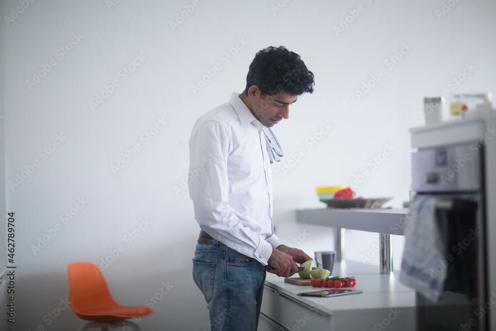 Man standing in kitchen preparing vegetables Man standing in kitchen preparing vegetables