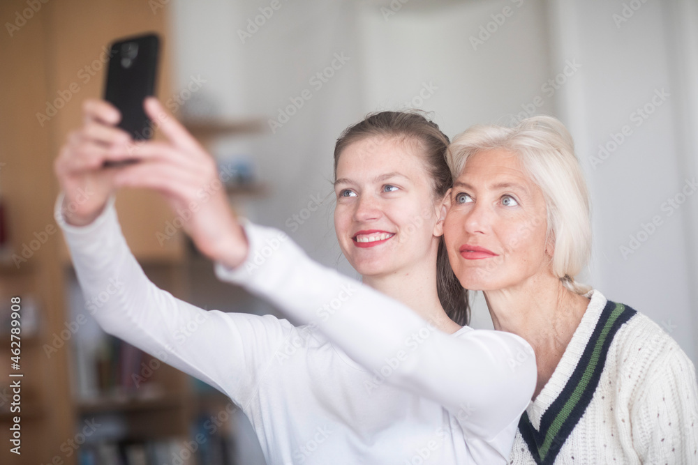 Portrait of smiling young woman taking selfie with her mother Portrait of smiling young woman taking selfie with her mother