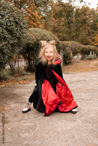 funny little kid on Halloween with horns. Sweets or life