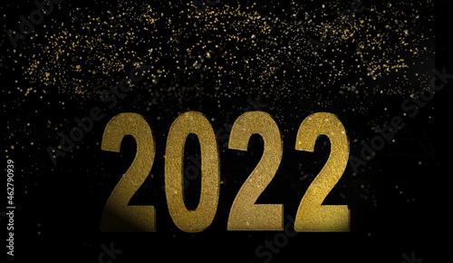 golden number 2022 new year on black background with bright lights