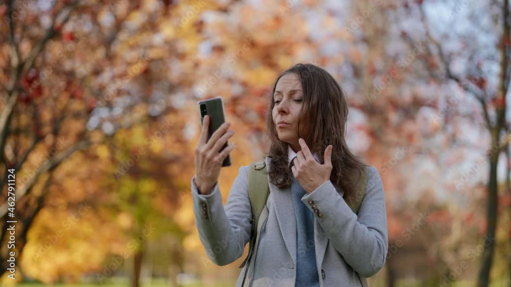 An adult pretty female tourist on a video call on the Internet. The influence of a travel blogger or social networks. Genuine emotions of a vacationer An adult pretty female tourist on a video call on the Internet. The influence of a travel blogger or social networks. Genuine emotions of a vacationer