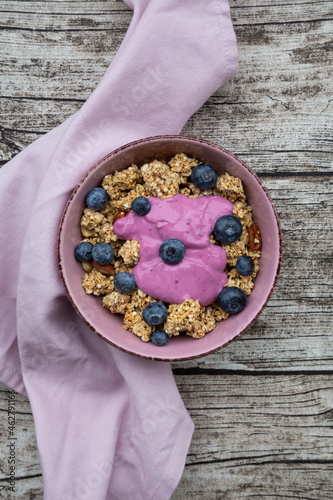 Bowl of Granola with almonds, blueberries and bluebery yoghurt