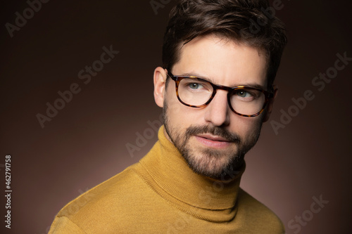 Portrait of confident man wearing glasses and yellow sweater photo