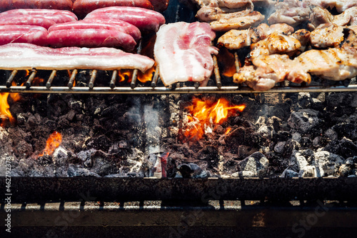 Close-up of meat and coals on barbecue grill in yard photo