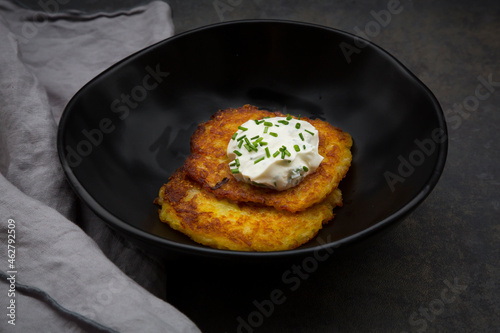 Potato fritters with herbed curd cheese in bowl photo