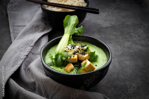 Green thai curry with spinach, pak choi, tofu, sour cream, black sesame and jasmine rice photo