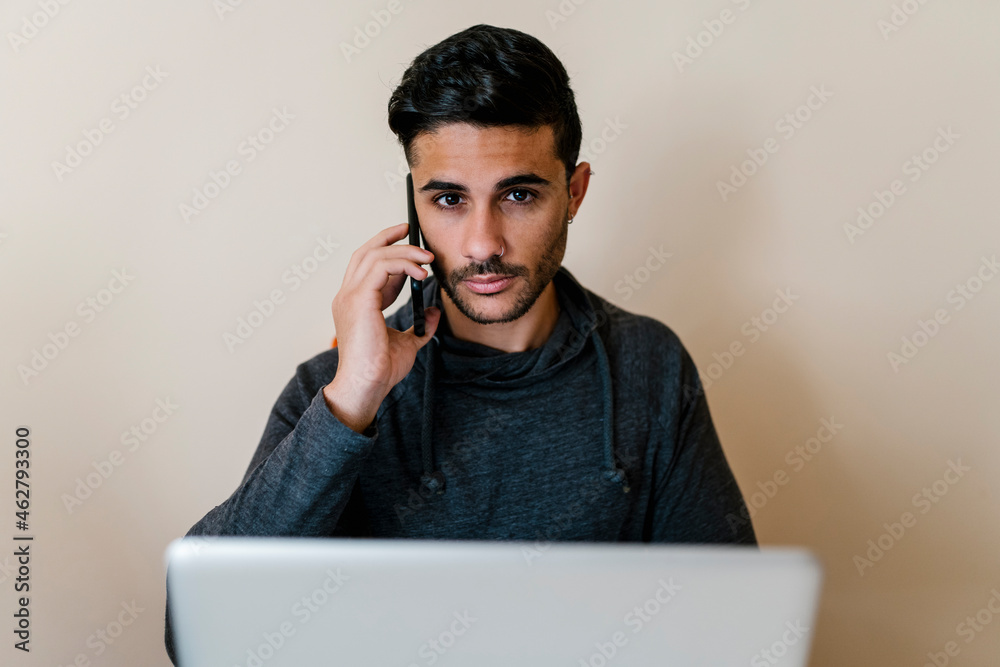 Man talking on mobile phone in living room Man talking on mobile phone in living room