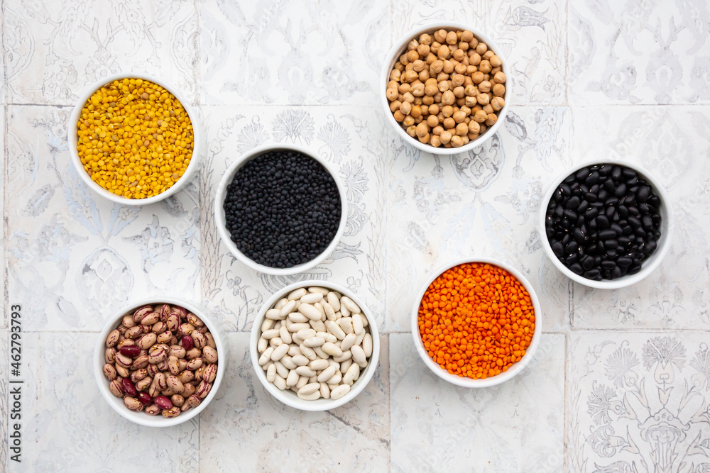 Various legumes in bowls: chickpeas, cannellini beans, quail beans, black beans, yellow lentils, red lentils, black lentils Various legumes in bowls: chickpeas, cannellini beans, quail beans, black beans, yellow lentils, red lentils, black lentils