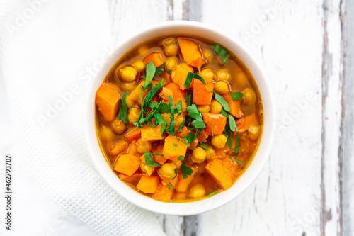 Bowl of oriental pumpkin stew with red kuri squash, roasted turmeric chick-peas and parsley photo