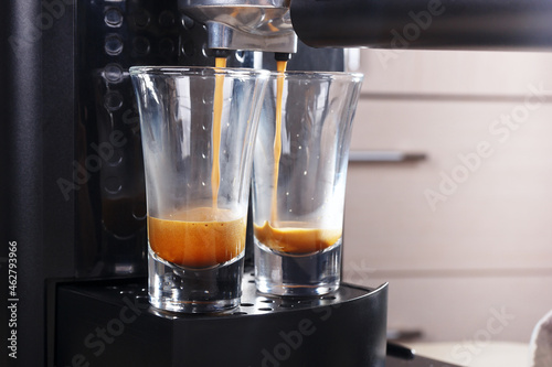 Making two short glasses of espresso in carob coffee maker.