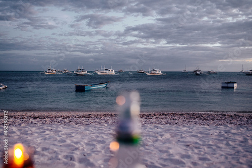 Boats at shore of Malapascua island at dusk, Philippines photo