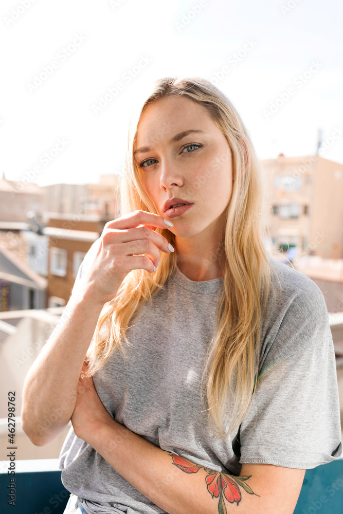 Portrait of blond young woman on balcony Portrait of blond young woman on balcony