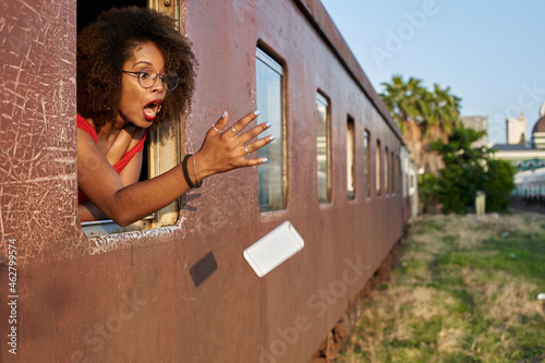 Woman's phone falling out of train window photo