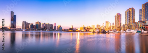 Modern buildings in front of Yarra River at Melbourne Docklands against sky at sunset, Victoria, Australia photo