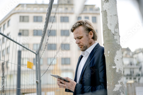 Businessman using tablet at a hoarding in the city