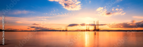 Scotland, Cromarty Firth, Oil platforms in sea at sunset photo