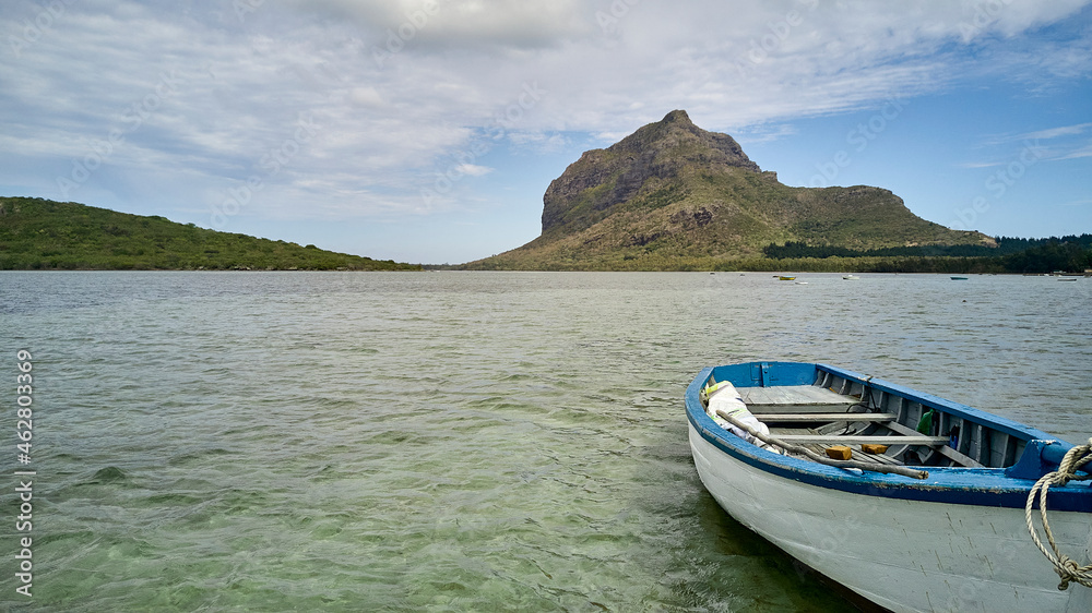 Mauritius, Empty rowboat floating in water with Le Morne Brabant peninsula in background Mauritius, Empty rowboat floating in water with Le Morne Brabant peninsula in background