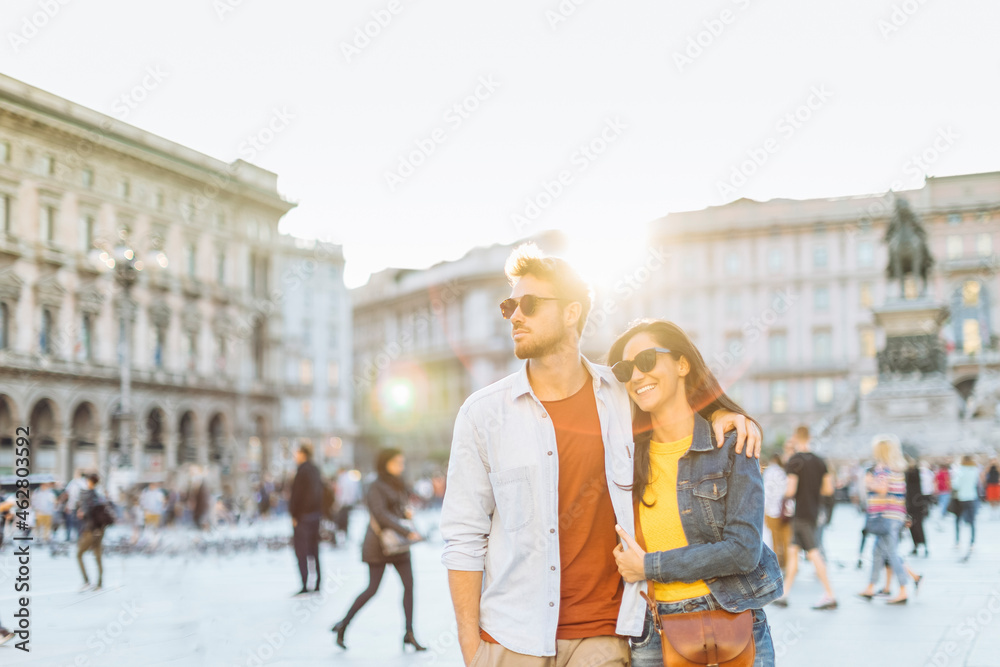 Happy young couple on a square in the city at sunset, Milan, Italy