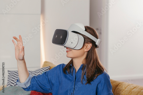 Young woman using VR glasses at home