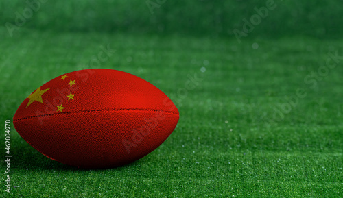 American football ball  with China flag on green grass background  close up