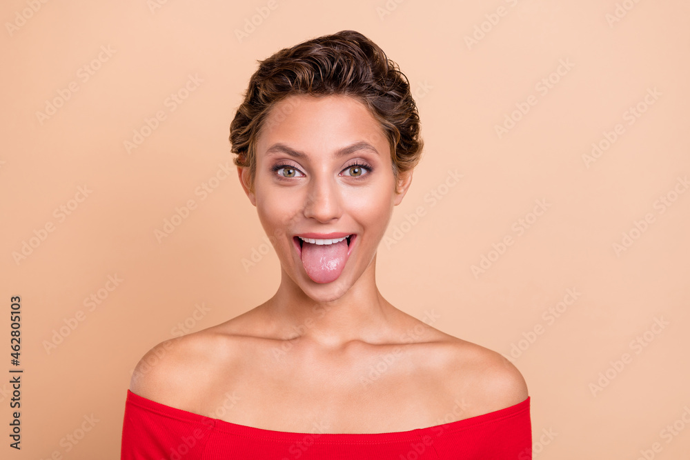 Photo of positive funky cheerful lady stick out tongue make silly face reaction isolated on pastel beige color background Photo of positive funky cheerful lady stick out tongue make silly face reaction isolated on pastel beige color background