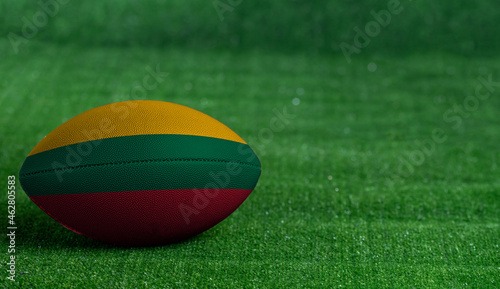 American football ball  with Lithuania flag on green grass background  close up
