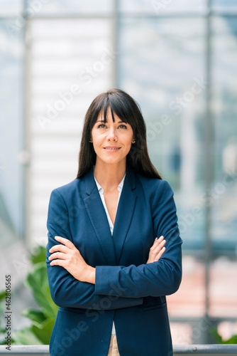 Female entrepreneur with arms crossed looking away in office photo