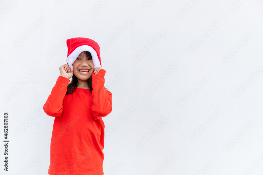 Asian little girl in red Santa hat on white background. Asian little girl in red Santa hat on white background.