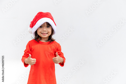 Asian little girl in red Santa hat on white background.