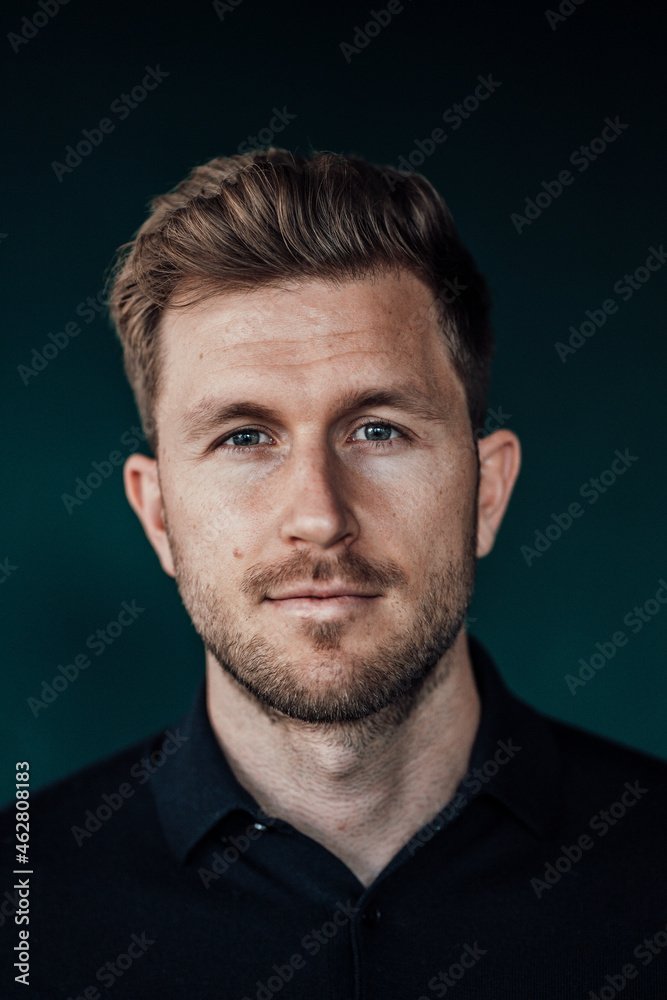 Businessman staring while standing against green background Businessman staring while standing against green background