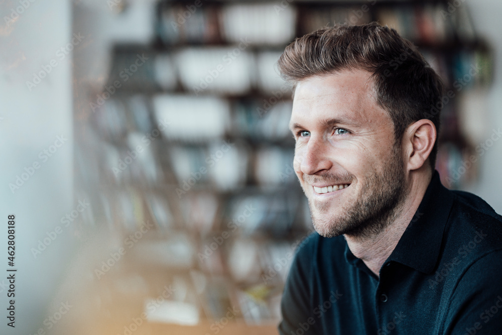 Smiling businessman looking away while sitting at cafe Smiling businessman looking away while sitting at cafe