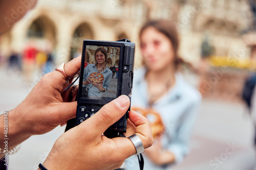 Young couple taking a photo, woman with brezel in Munich, Germany