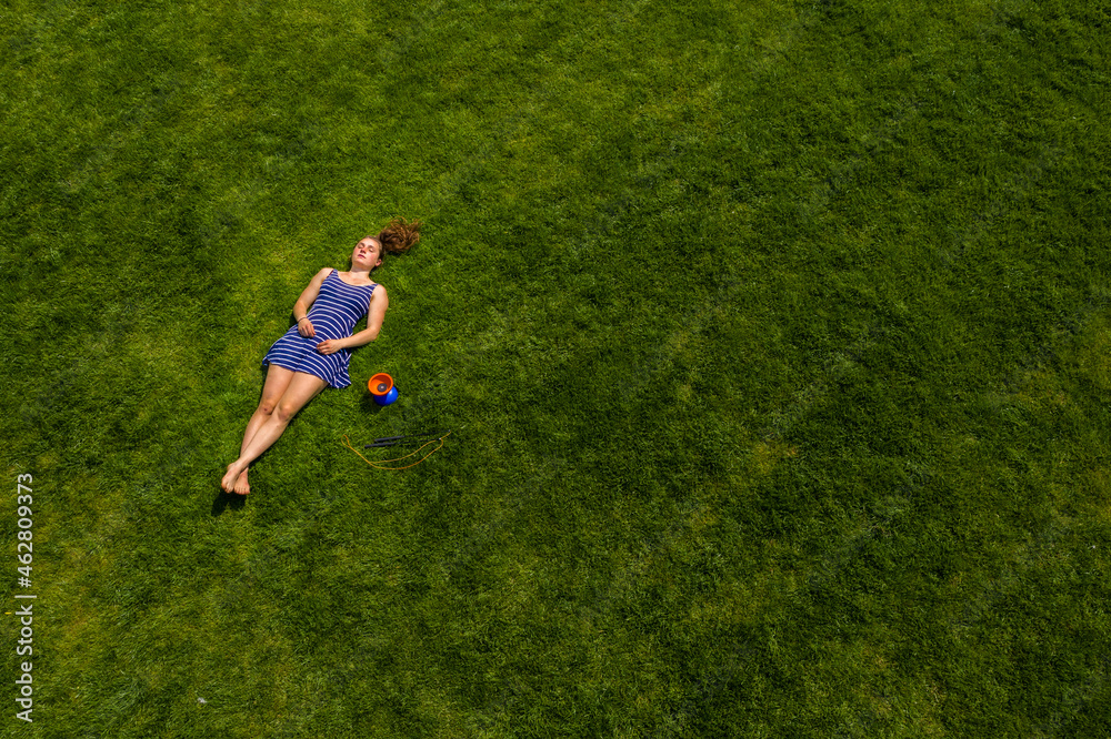 Aerial view of a young woman lying on a meadow