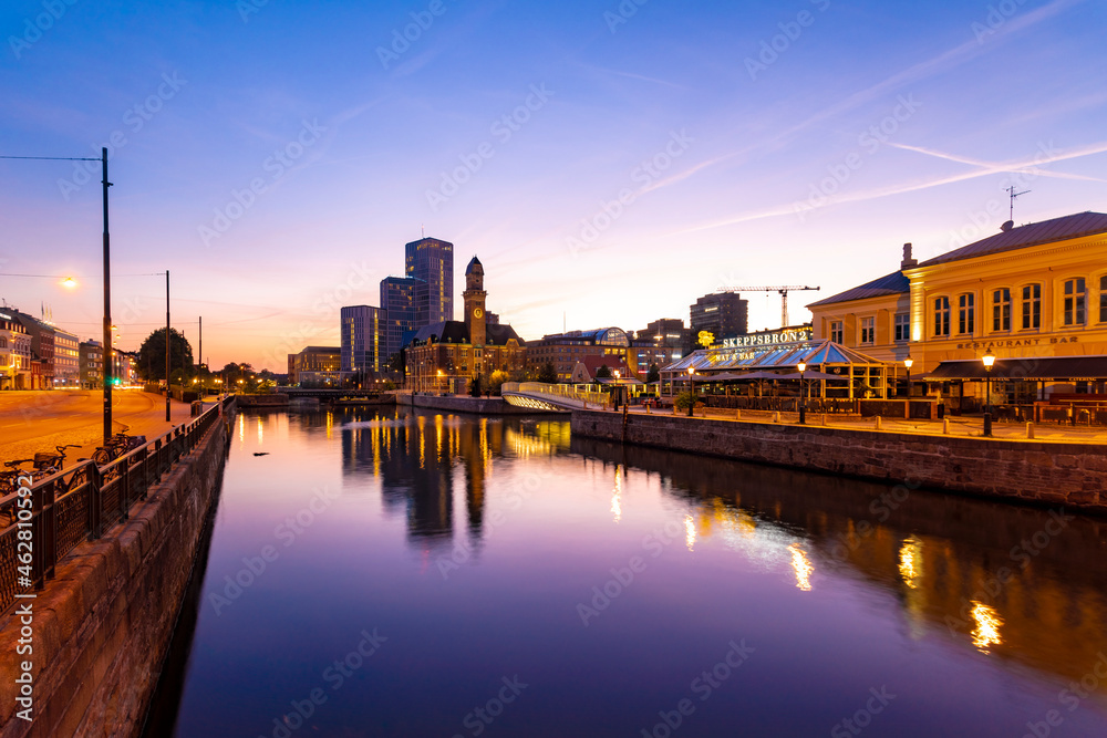Buildings by canal against sky at dusk in Malmo, Sweden Buildings by canal against sky at dusk in Malmo, Sweden