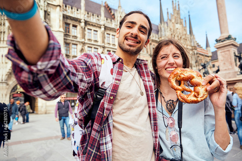 Young couple taking a selfie with brezel in Munich, Germany photo