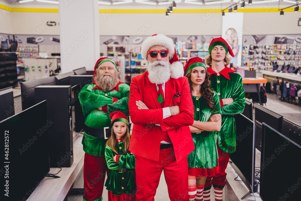 Naklejka premium Portrait of attractive content funky company elfs super hero buying goods devices folded arms December bargain at mall store indoors