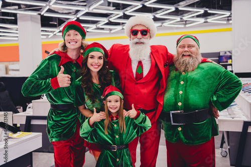 Portrait of attractive cheerful glad funky group elfs buyers buying purchase showing thumbup recommend bargain at store market indoors