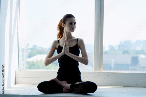 woman meditates near window calm balance exercise