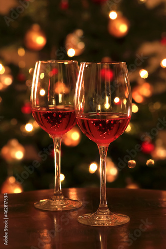 Rose wine in shiny wineglass in front of Christmas tree photo