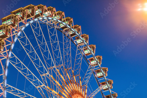 Germany, Bavaria, Munich, Low angle view of Ferris wheel glowing against clear sky at dusk