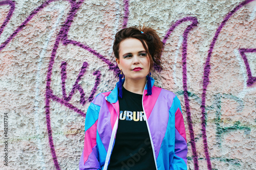 1980s retro-styled woman standing in front of a wall with graffiti photo