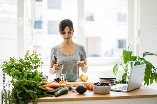 Woman preparing healthy food in her kitchen photo